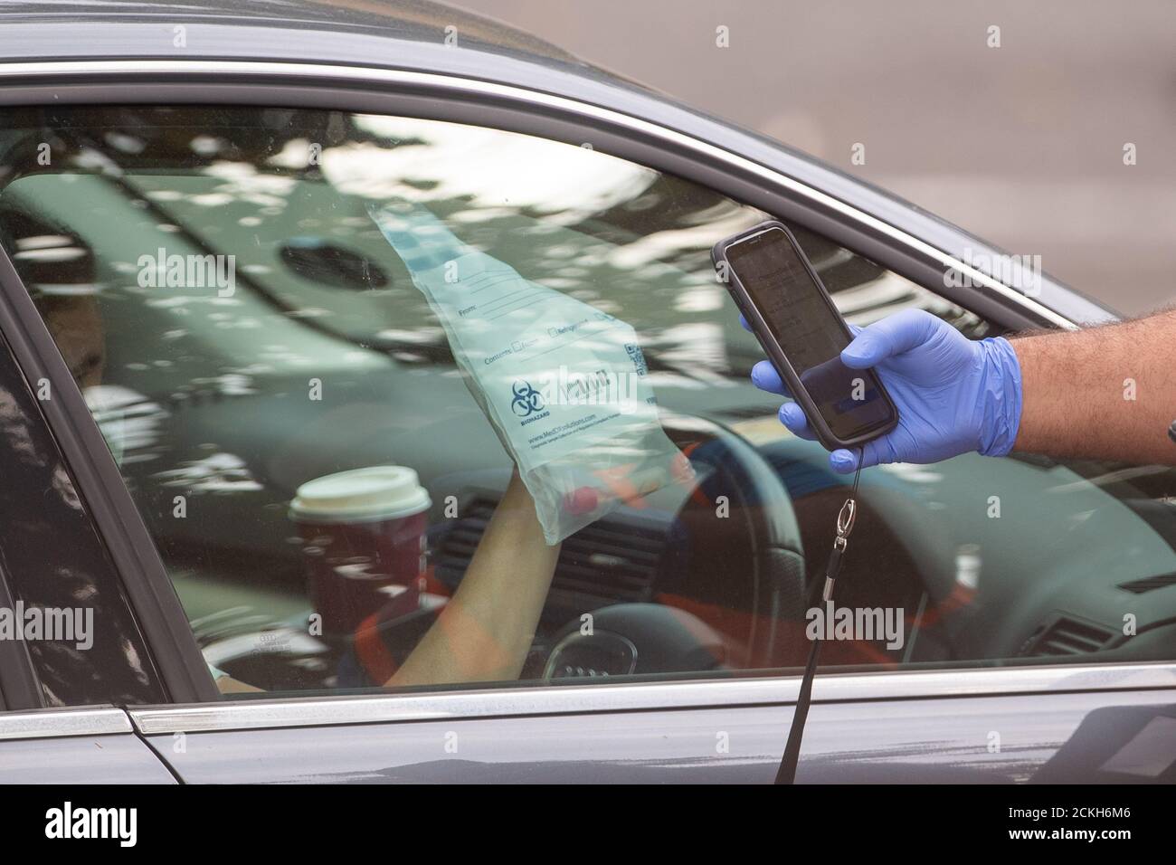 Un test du coronavirus est effectué par une fenêtre de voiture dans un centre de dépistage du coronavirus à Bedford. Banque D'Images