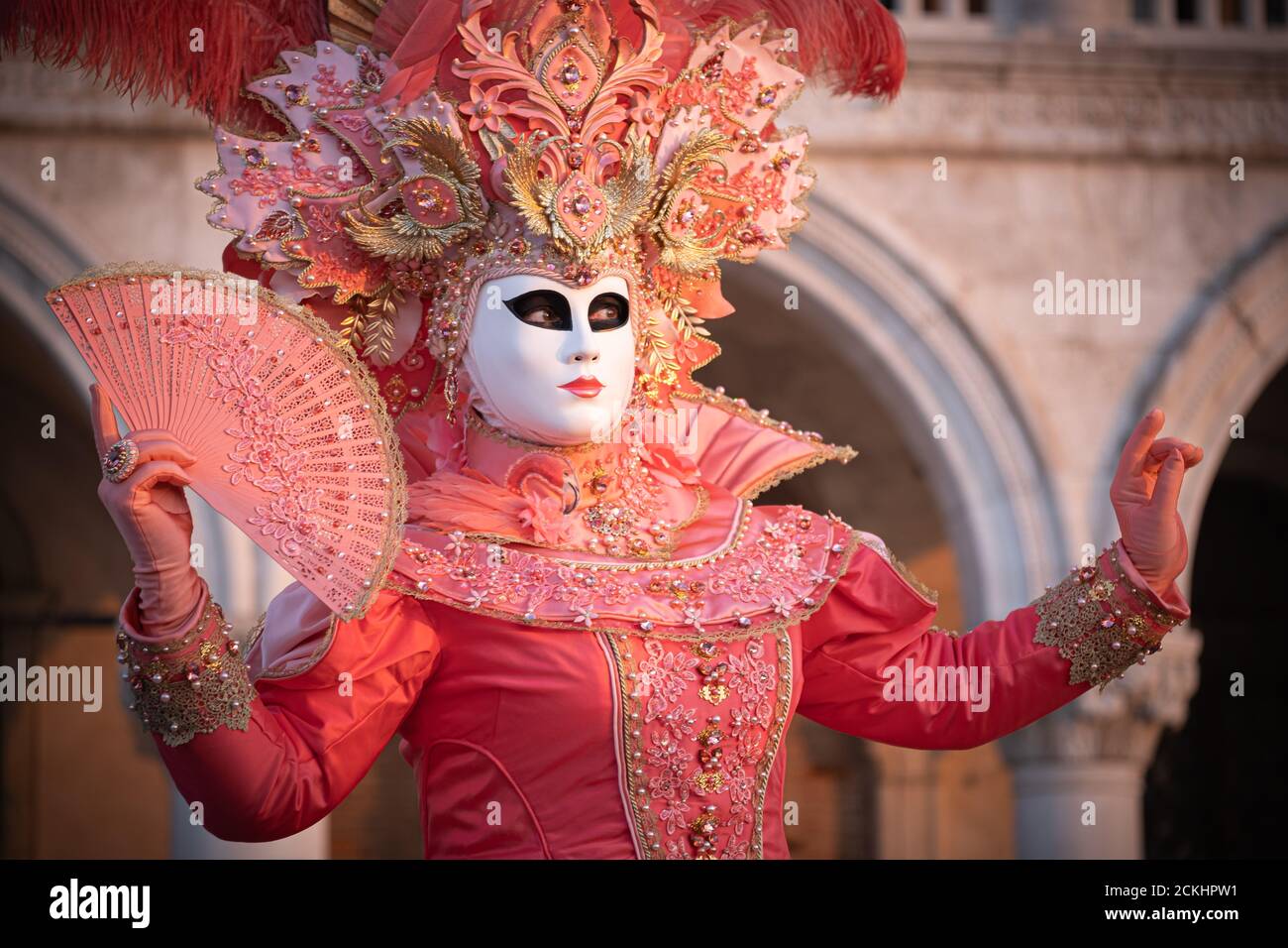 Déguisement/masque traditionnel de carnaval posé tôt le matin au bord de l'eau pendant un lever de soleil au carnaval annuel à Venise, Italie Banque D'Images Déguisement/masque traditionnel de carnaval posé tôt le matin au bord de l'eau pendant un lever de soleil au carnaval annuel à Venise, Italie Banque D'Images