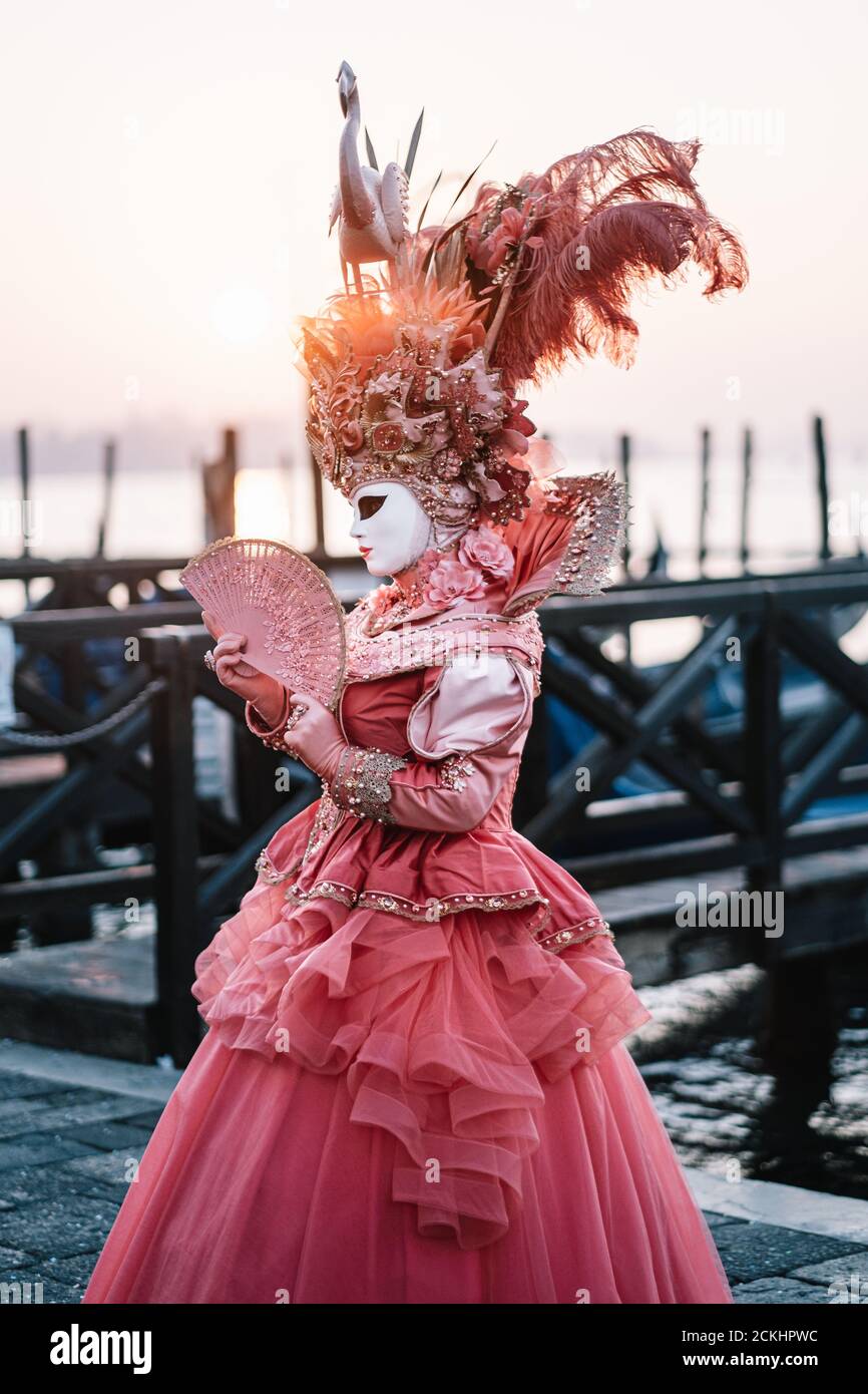 Déguisement/masque traditionnel de carnaval posé tôt le matin au bord de l'eau pendant un lever de soleil au carnaval annuel à Venise, Italie Banque D'Images Déguisement/masque traditionnel de carnaval posé tôt le matin au bord de l'eau pendant un lever de soleil au carnaval annuel à Venise, Italie Banque D'Images