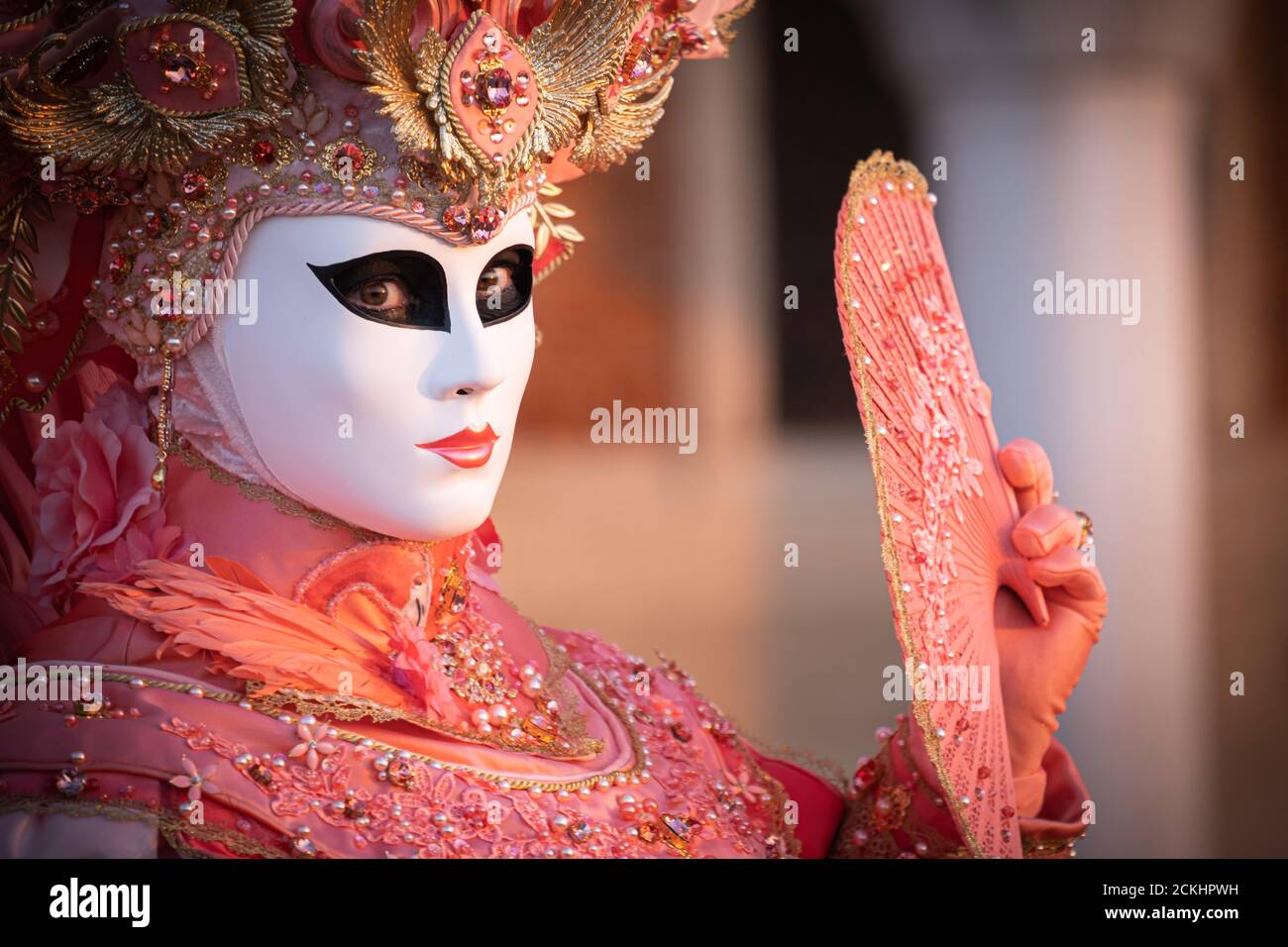 Déguisement/masque traditionnel de carnaval posé tôt le matin au bord de l'eau pendant un lever de soleil au carnaval annuel à Venise, Italie Banque D'Images