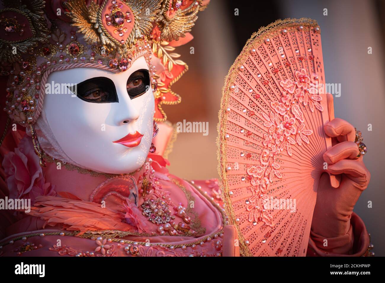 Déguisement/masque traditionnel de carnaval posé tôt le matin au bord de l'eau pendant un lever de soleil au carnaval annuel à Venise, Italie Banque D'Images