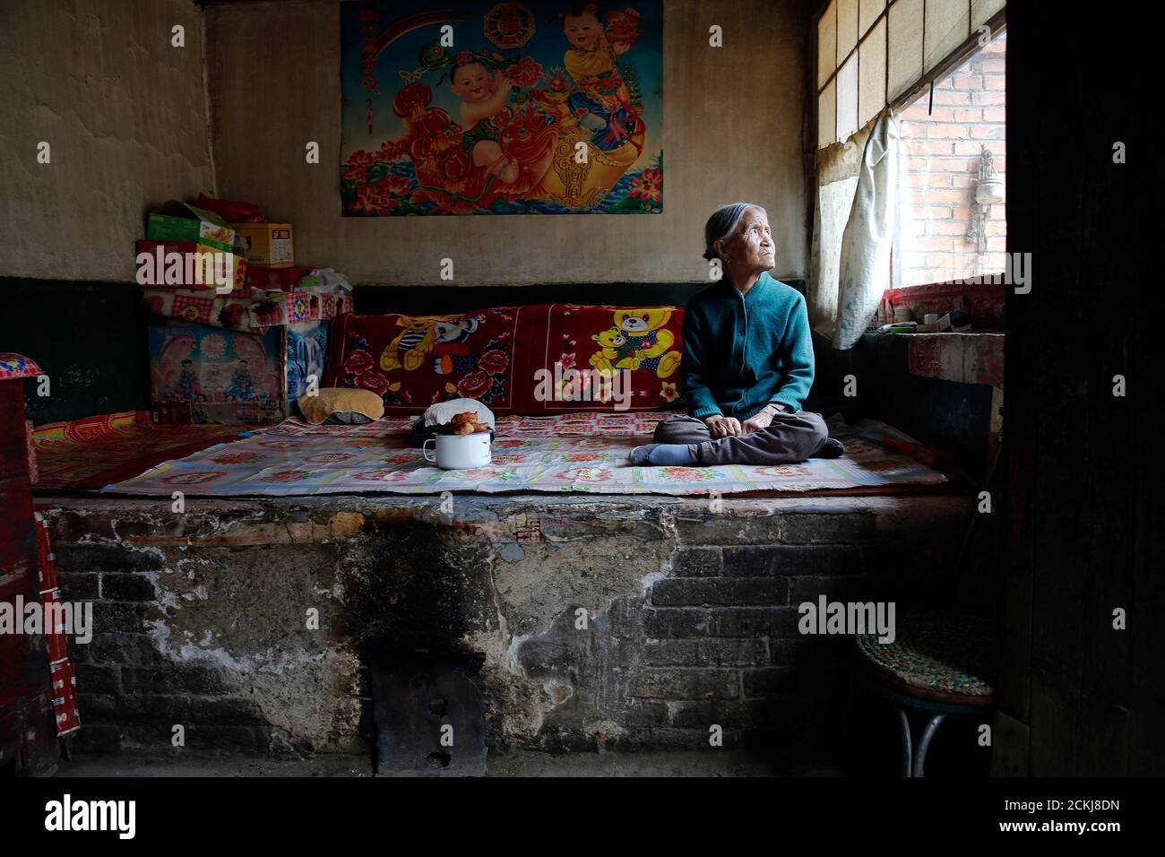 L'ancienne 'femme de confort' chinoise Zhang Xiantu repose sur un lit traditionnel en brique dans sa maison dans la ville de Xiyan, province du Shanxi, Chine, le 18 juillet 2015. « les femmes de confort » est l'euphémisme japonais pour les femmes qui ont été forcées à la prostitution et victimes d'abus sexuels dans des maisons de prostitution militaires japonaises avant et pendant la Seconde Guerre mondiale. Xiantu est la seule 'femme de réconfort' survivante des 16 plaignants de Shanxi qui ont poursuivi le gouvernement japonais en 1995 pour avoir enlevé des filles et les utiliser comme 'femme de réconfort' pendant la deuxième Guerre mondiale. Selon les informations de la Commission d'enquête de la Chine sur les faits de Comfort Women be Banque D'Images