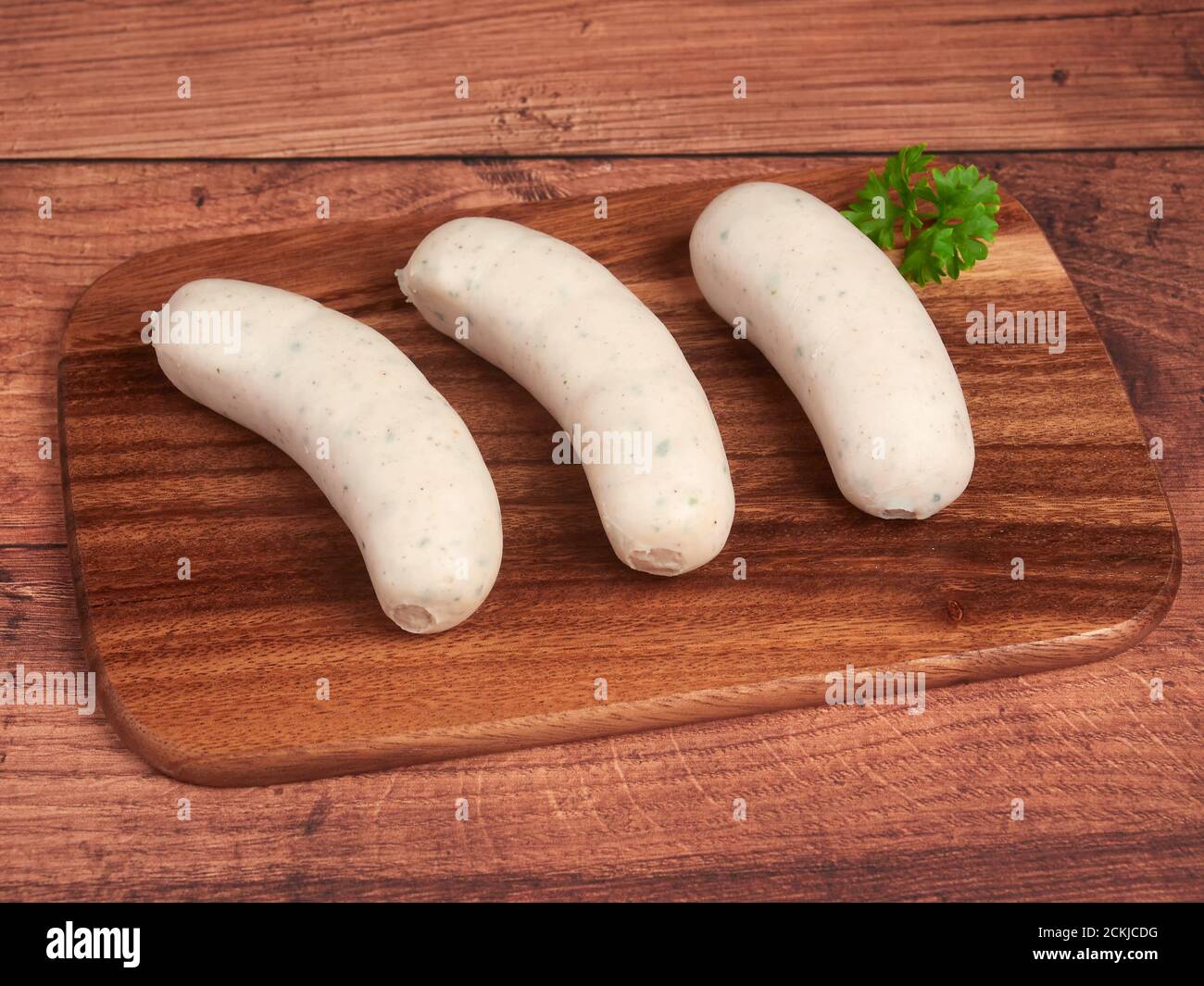 Saucisses traditionnelles blanches bavaroises (weisswurst) sur une planche de bois Banque D'Images