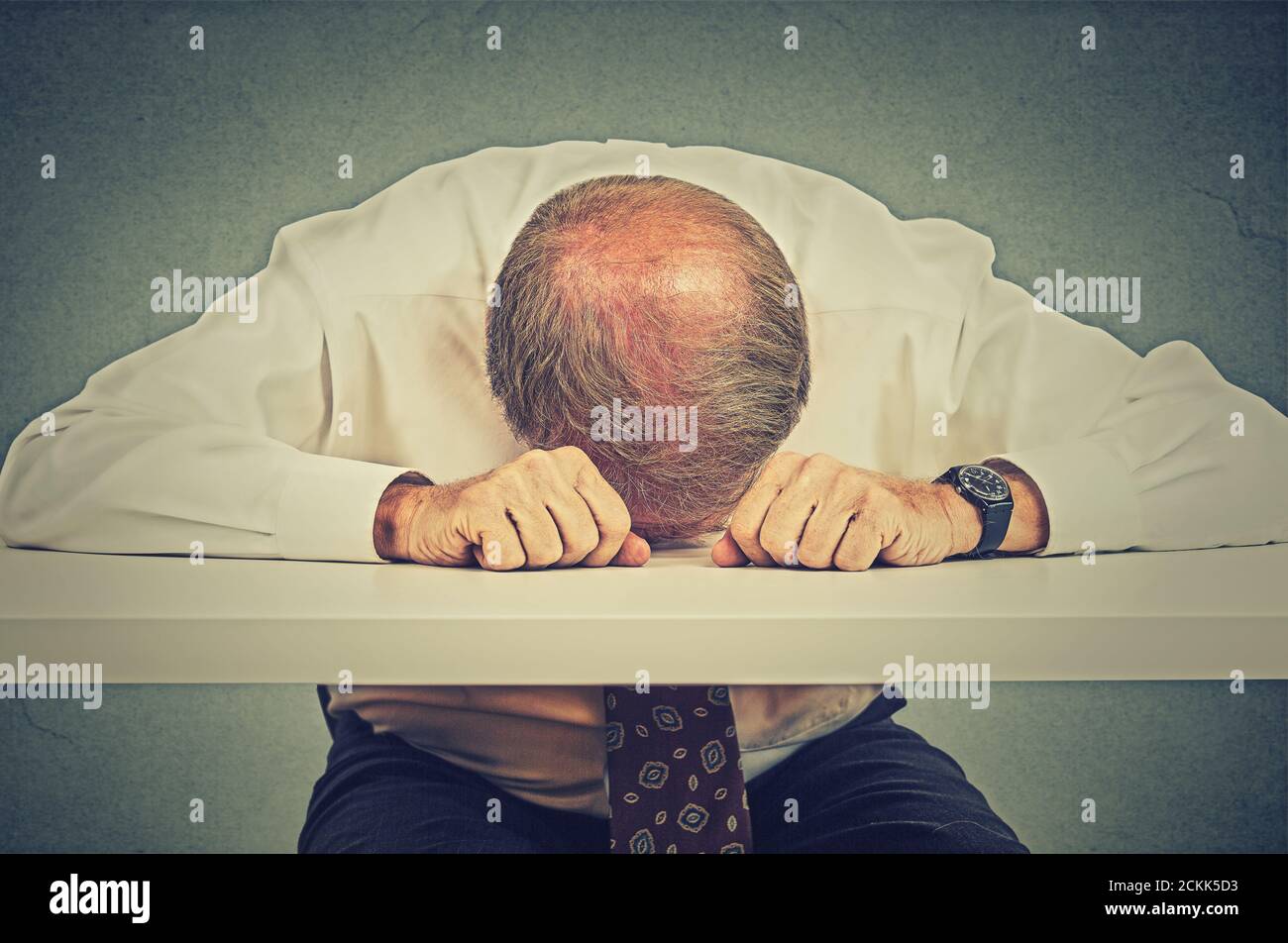 Homme d'affaires âgé fatigué dormant dans son bureau Banque D'Images