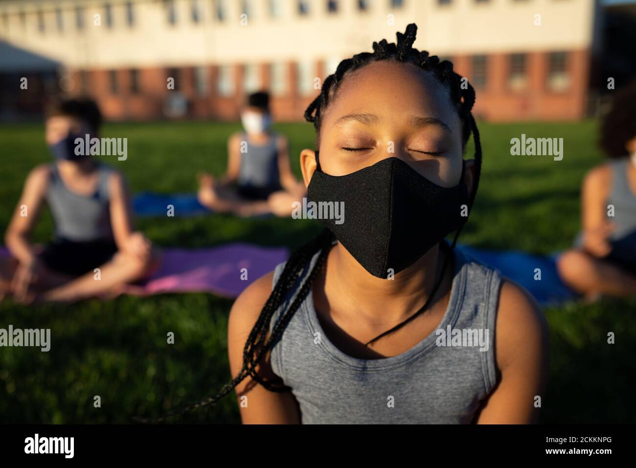 Fille portant un masque de yoga dans le jardin Banque D'Images