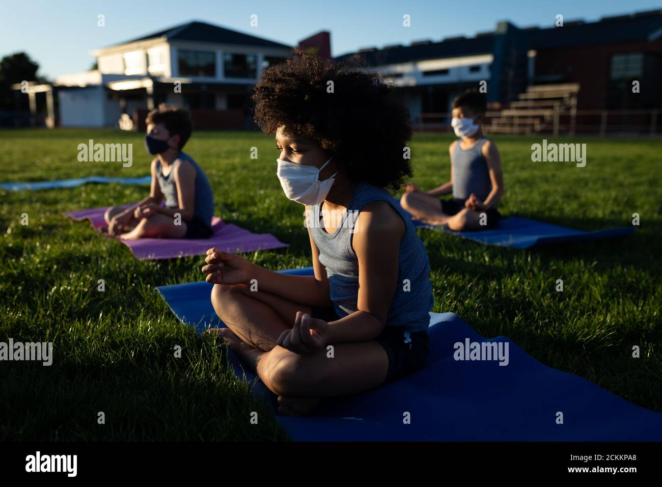 Groupe d'enfants portant des masques de yoga dans le jardin Banque D'Images