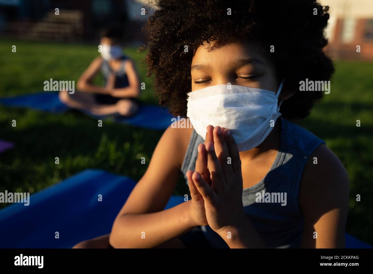 Garçon portant un masque de yoga dans le jardin Banque D'Images