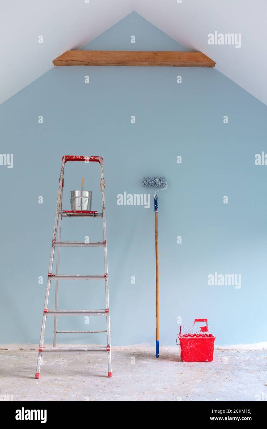 Peindre les outils avec une échelle contre un nouveau bleu clair mur Banque D'Images