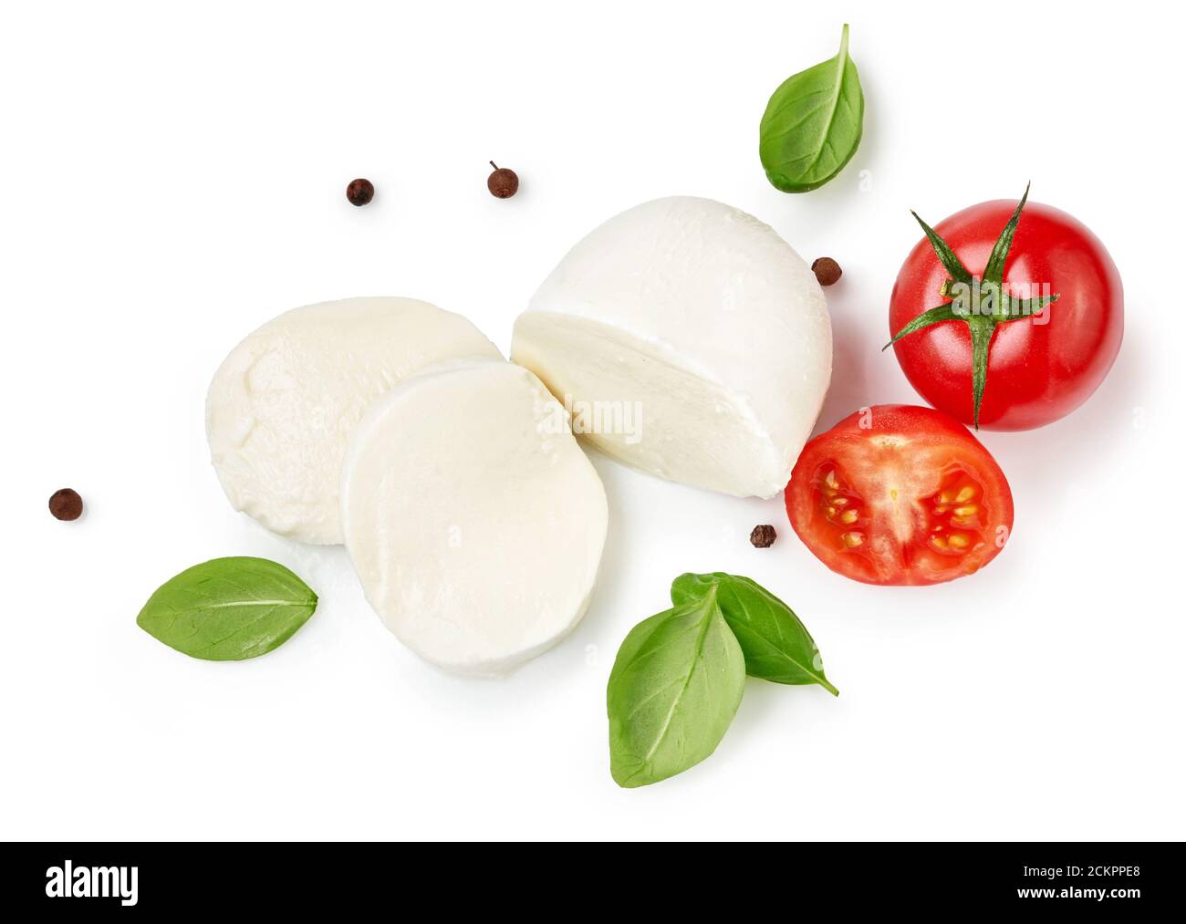 Morceaux de mozzarella Buffalo avec feuilles de basilic. Vue de dessus de fromage en tranches avec tomates isolées sur fond blanc. Banque D'Images