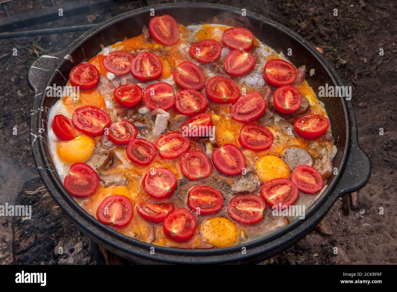 Œufs brouillés avec tranches de tomate dans une grande poêle plate, à l'extérieur Banque D'Images