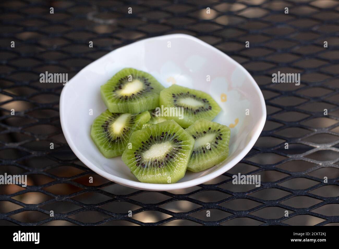 Petit bol de kiwi tranché sur une table en métal Banque D'Images