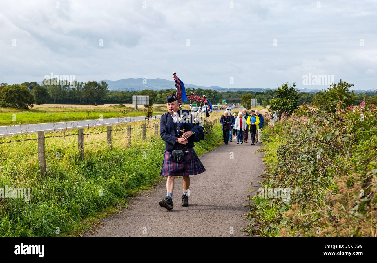 Un joueur de cornemuse mène un cortège à la commémoration de la bataille de Pinkie Cleugh par le site du champ de bataille de l'A1, East Lothian, Écosse, Royaume-Uni Banque D'Images