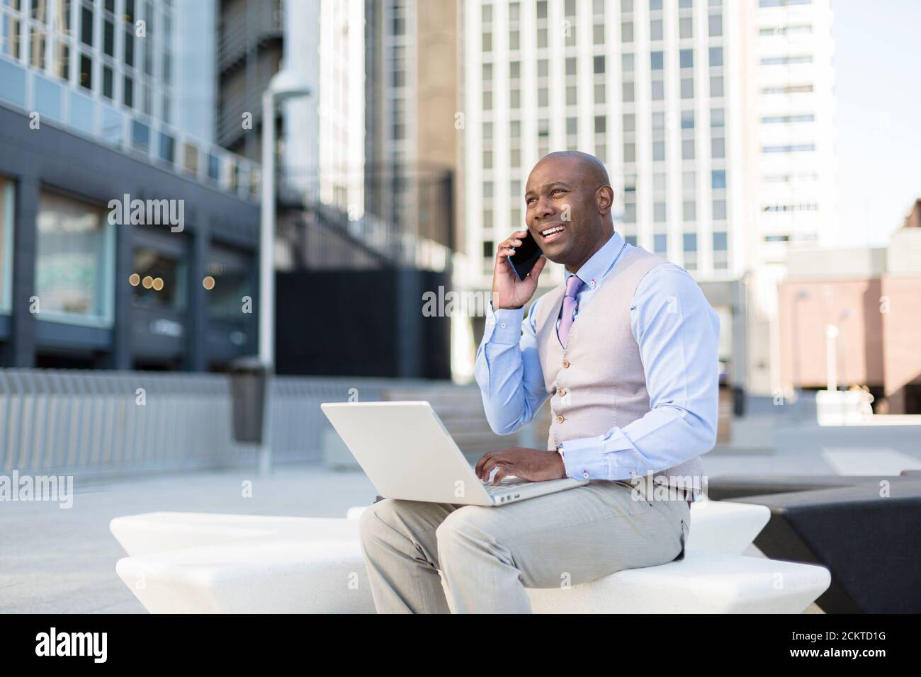 Gros plan de l'homme noir d'entreprise travaillant avec son ordinateur portable dans la rue. Concept de nouvelles façons d'affaires. Banque D'Images