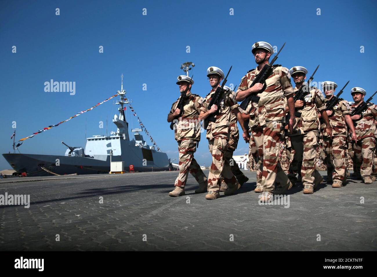 Les membres des forces armées françaises défilent devant la frégate  française Courbet tout en participant à un mariage militaire à la base  navale française d'Abu Dhabi, Émirats arabes Unis le 24 novembre