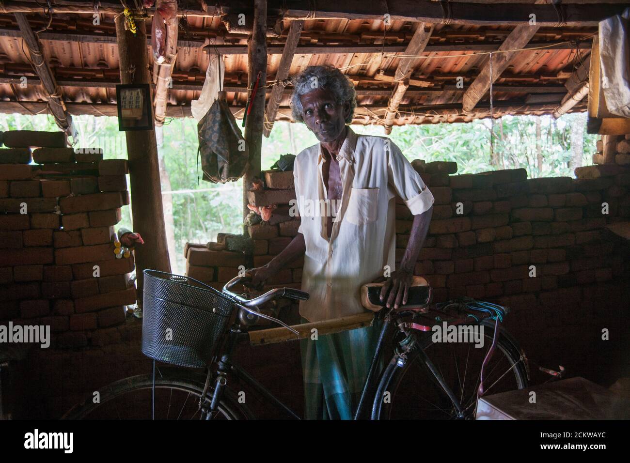 Domicile de T.H. Piyadasa, 62 ans, et vit avec sa femme de 60 ans. Il a vendu du poisson frais sur son vélo mais a été forcé de renoncer quand son asthme a été très mauvais. La vie est très difficile pour le couple qui dépend d'une petite quantité payée par le gouvernement et de vendre des fruits cultivés dans le jardin. Matara, Sri Lanka. Banque D'Images