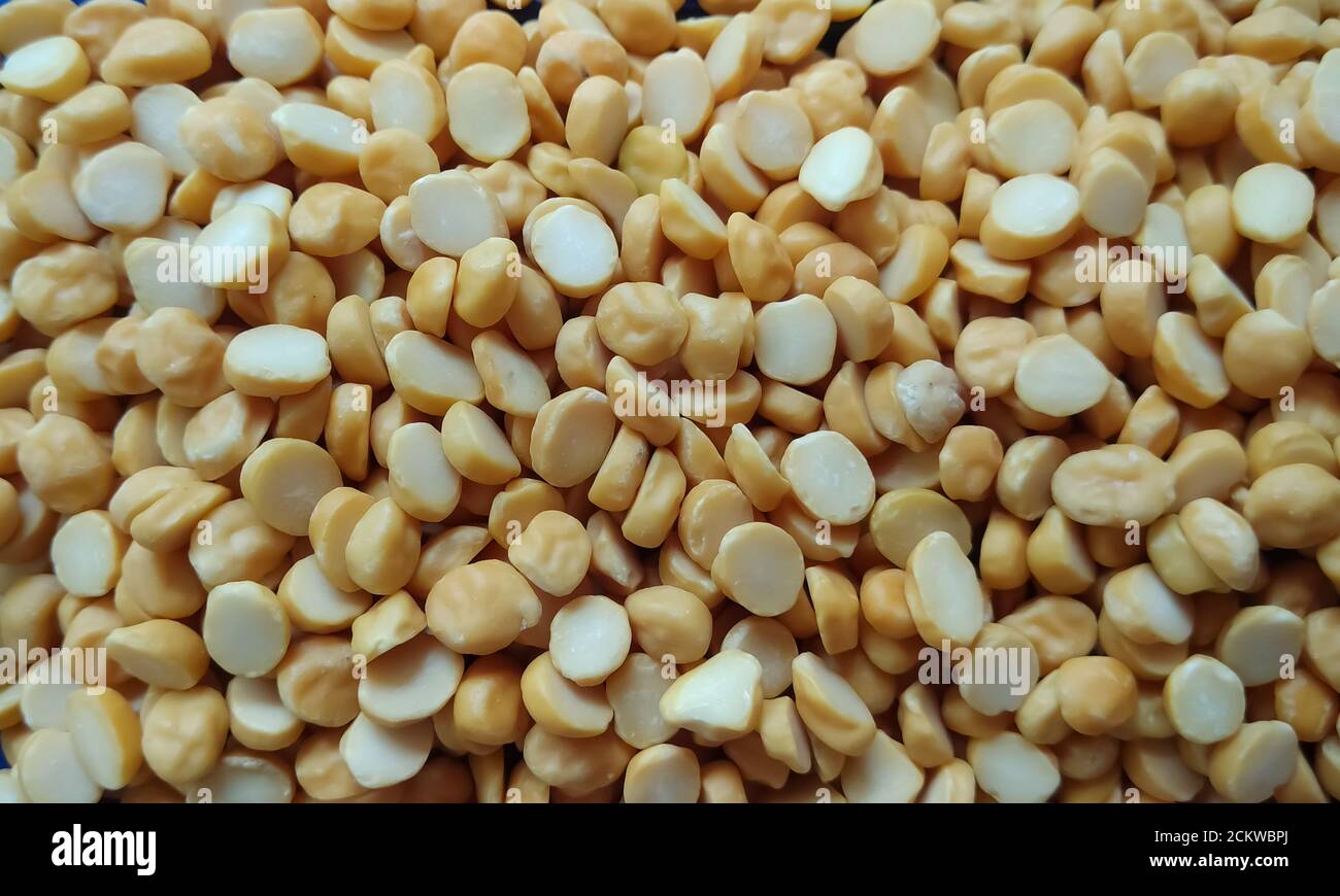 Le jaune divise les petits pois isolés sur fond plat avec une mise au point sélective. Banque D'Images