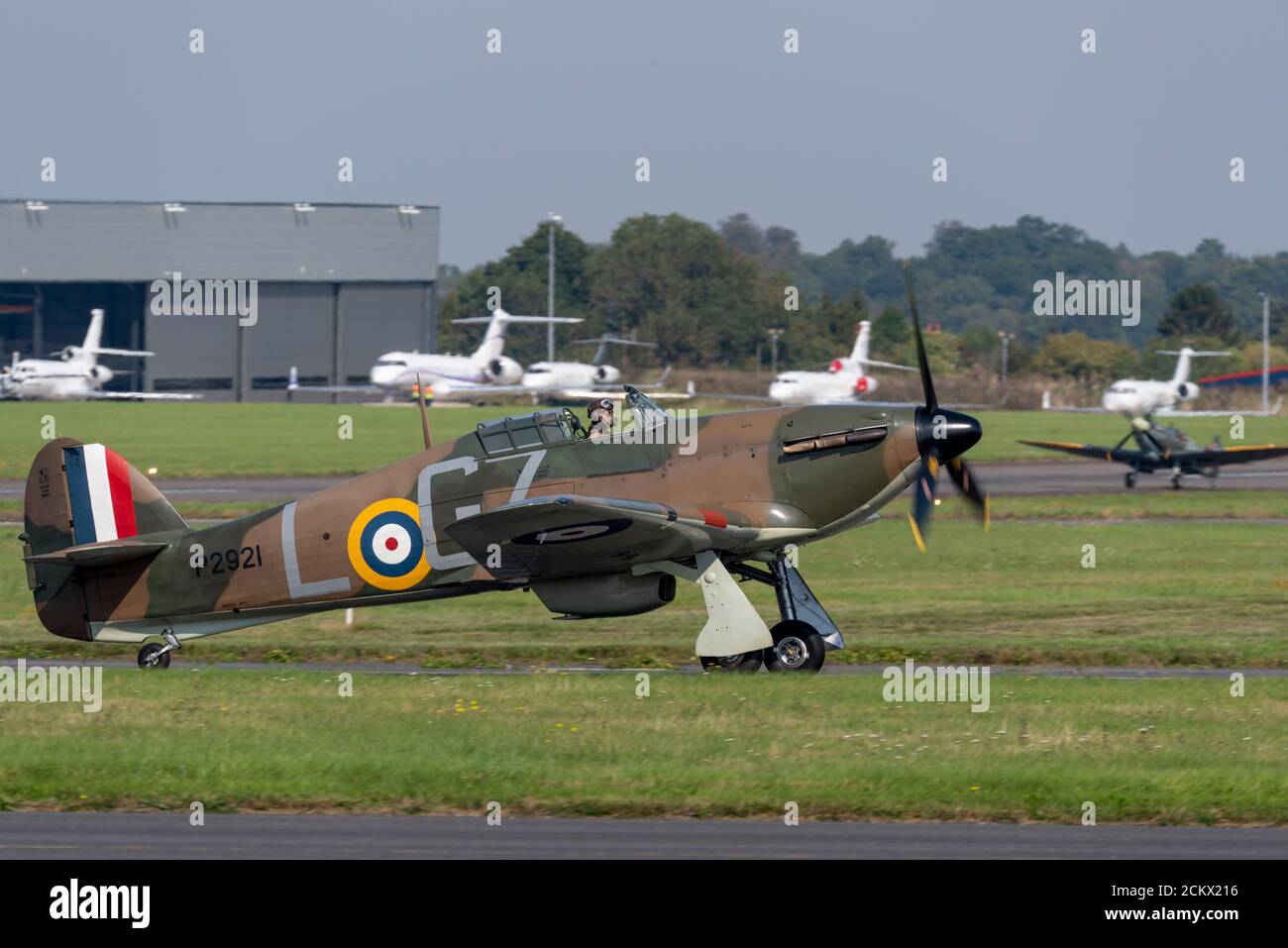 Hawker Hurricane et Supermarine Spitfire qui se jettent sur Biggin Hill après le défilé anniversaire de la bataille d'Angleterre, avec des avions d'affaires garés Banque D'Images