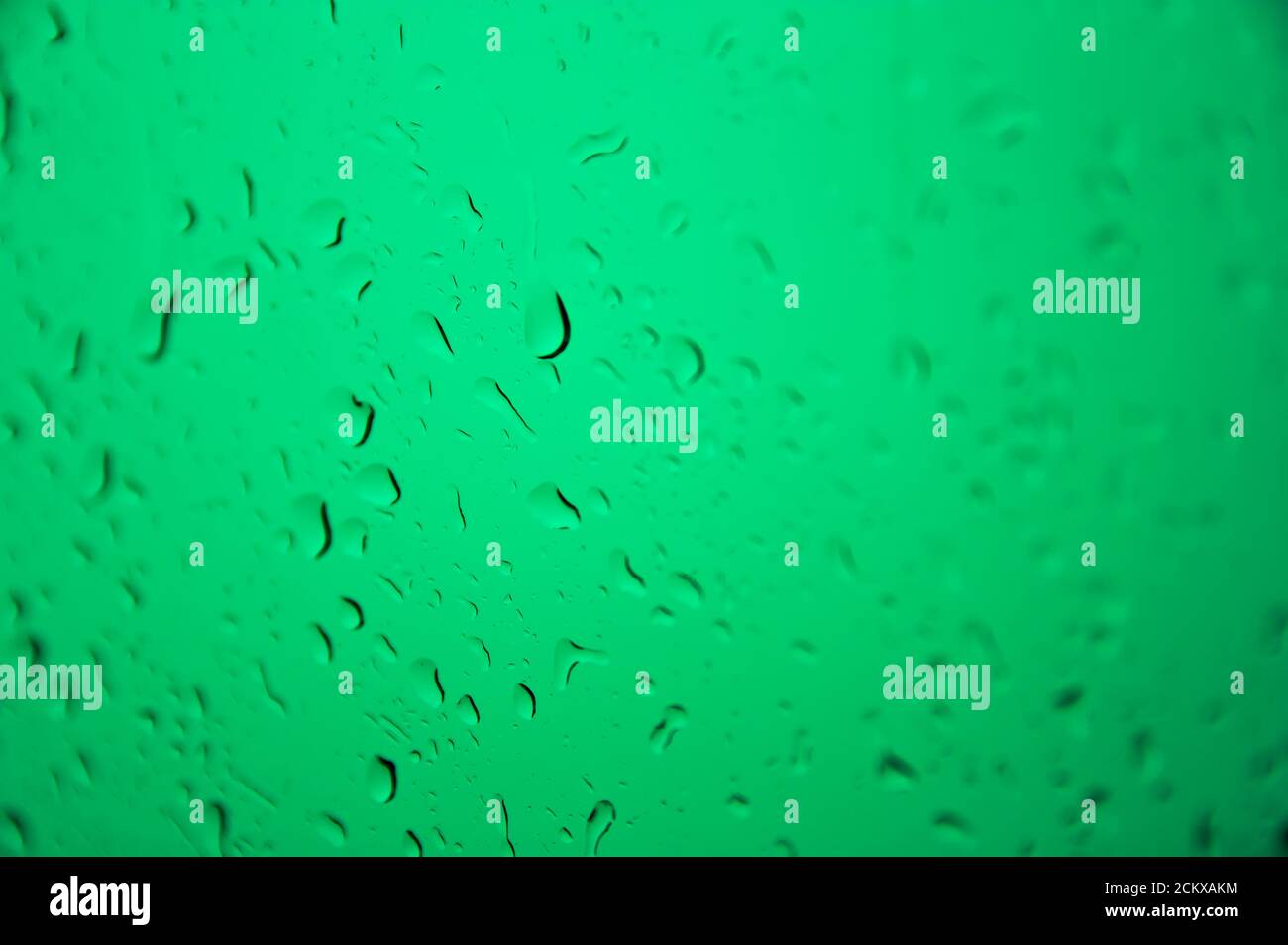 Image d'un verre humide avec des gouttes d'eau illuminées par une lumière verte. Conceptuel, Résumé Banque D'Images