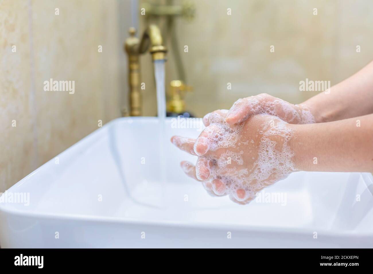 Femme se lavant et se désinfectant les mains avec du savon et de l'eau chaude dans le cadre des protocoles de prévention et de protection du coronavirus; cesser de propager l'hygie covid-19 Banque D'Images