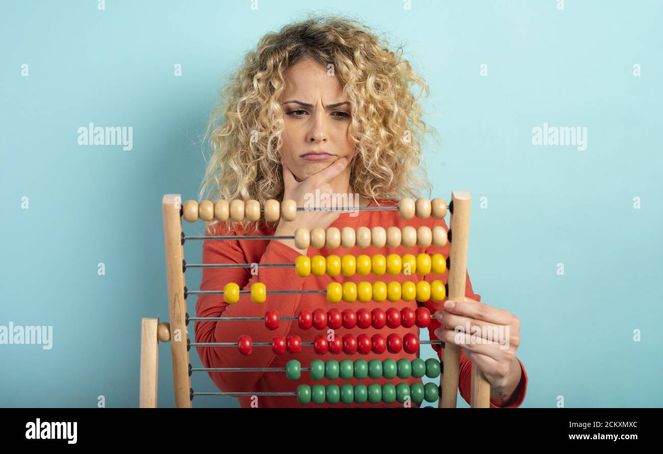 Fille avec abacus est confondu au sujet de la somme . fond cyan Banque D'Images