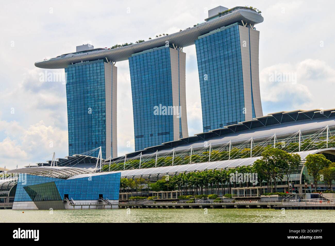 Ouvert en 2010, Marina Bay Sands est un hôtel de 2,561 chambres situé le long de Marina Bay à Singapour. Développé par Las Vegas Sands, il est facturé comme la propriété de casino autonome la plus chère au monde à 8 milliards de dollars. L'hôtel dispose d'un centre de congrès, de boutiques haut de gamme, de théâtres, de sept restaurants, d'une patinoire, d'un casino et est surmonté d'un Skypark de 340 mètres de long (310 mètres de long) d'une capacité de 3,900 personnes et d'une piscine à débordement, située sur la plus grande plateforme publique en porte-à-faux du monde. Banque D'Images