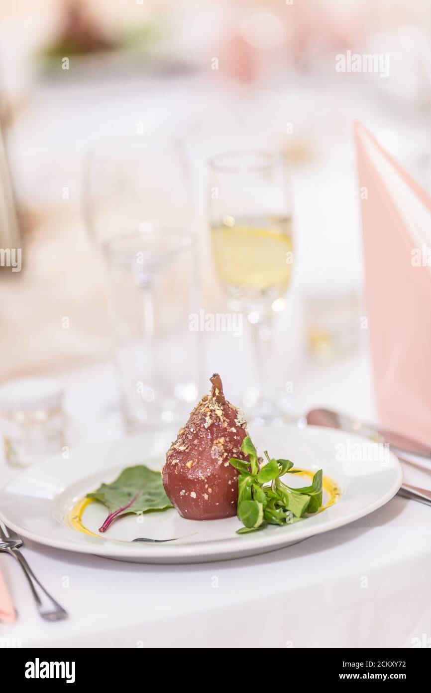 Poires grillées glacées aux noix saupoudrées sur un table de fête Banque D'Images Poires grillées glacées aux noix saupoudrées sur un table de fête Banque D'Images