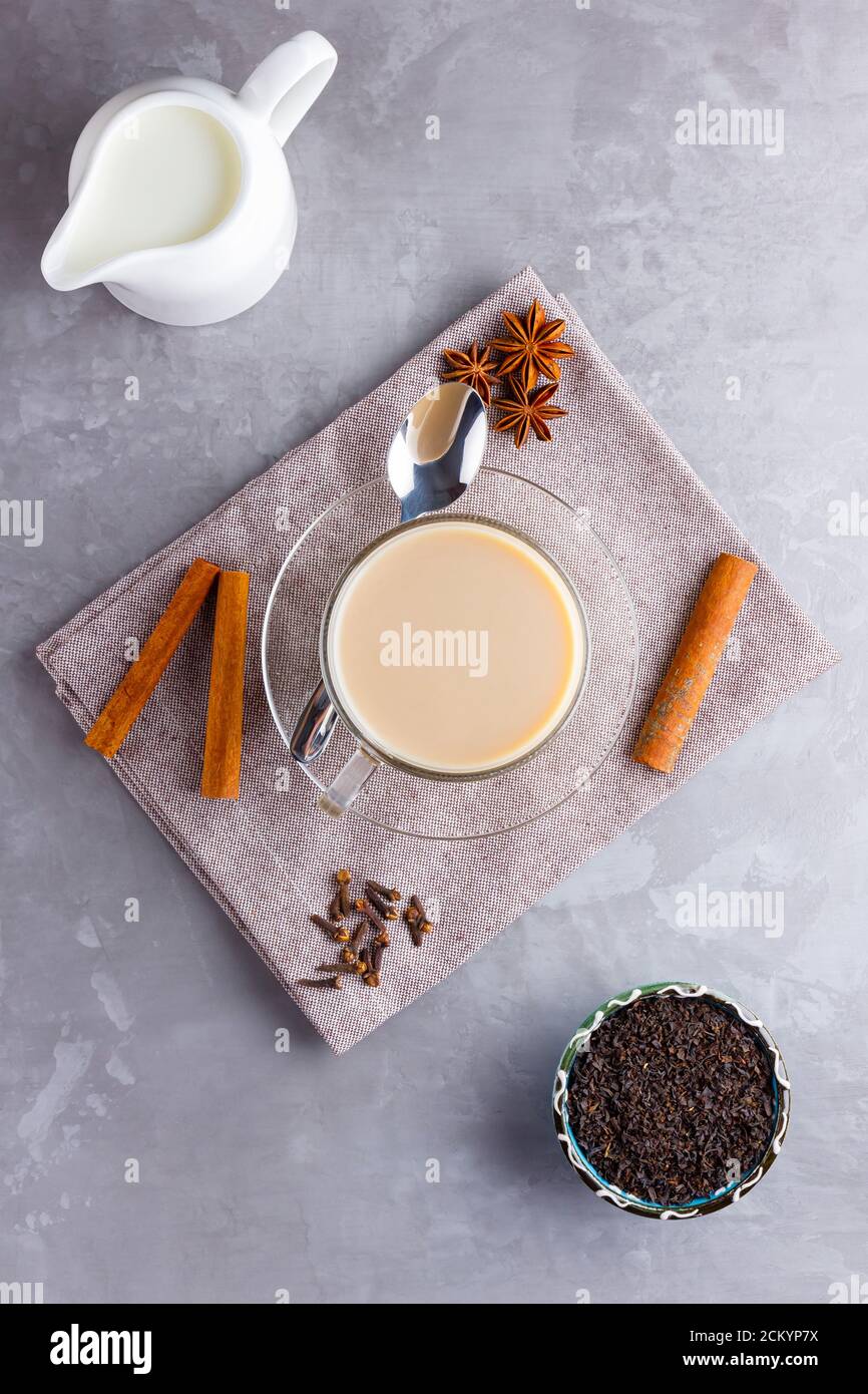 Thé Chai de masala. Boisson traditionnelle indienne - thé masala avec épices sur fond gris. Vue de dessus Banque D'Images
