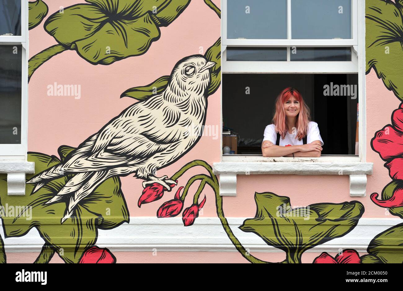 L'artiste Alex Lucas de Bristol avec la maison qu'elle peint À Cheltenham qui a coïncidé avec la célébration du Festival de peinture de Cheltenham art de la rue Banque D'Images