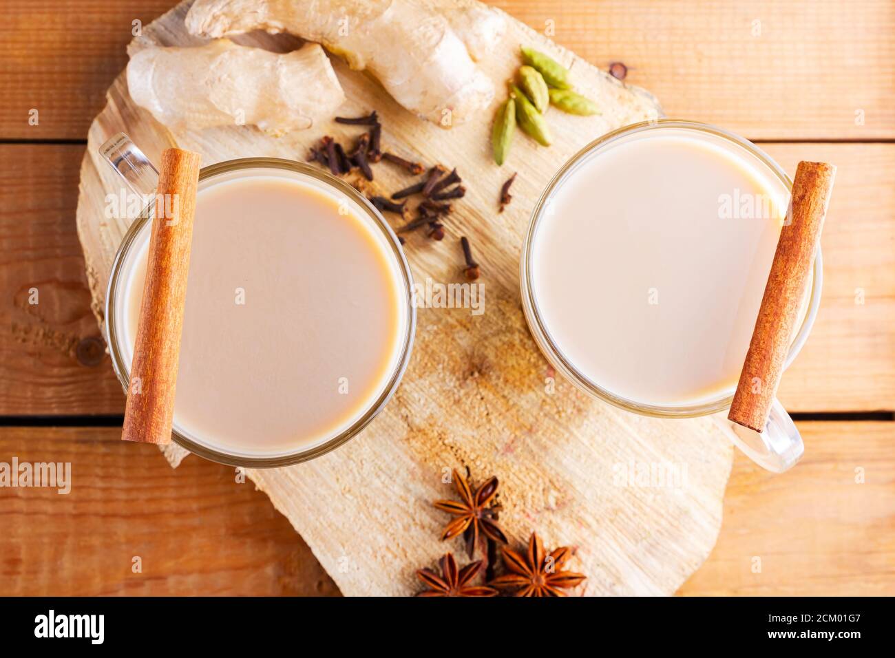 Thé Chai au masala sur un support en bois. Boisson traditionnelle indienne - thé masala avec épices sur fond de bois. Vue de dessus Banque D'Images