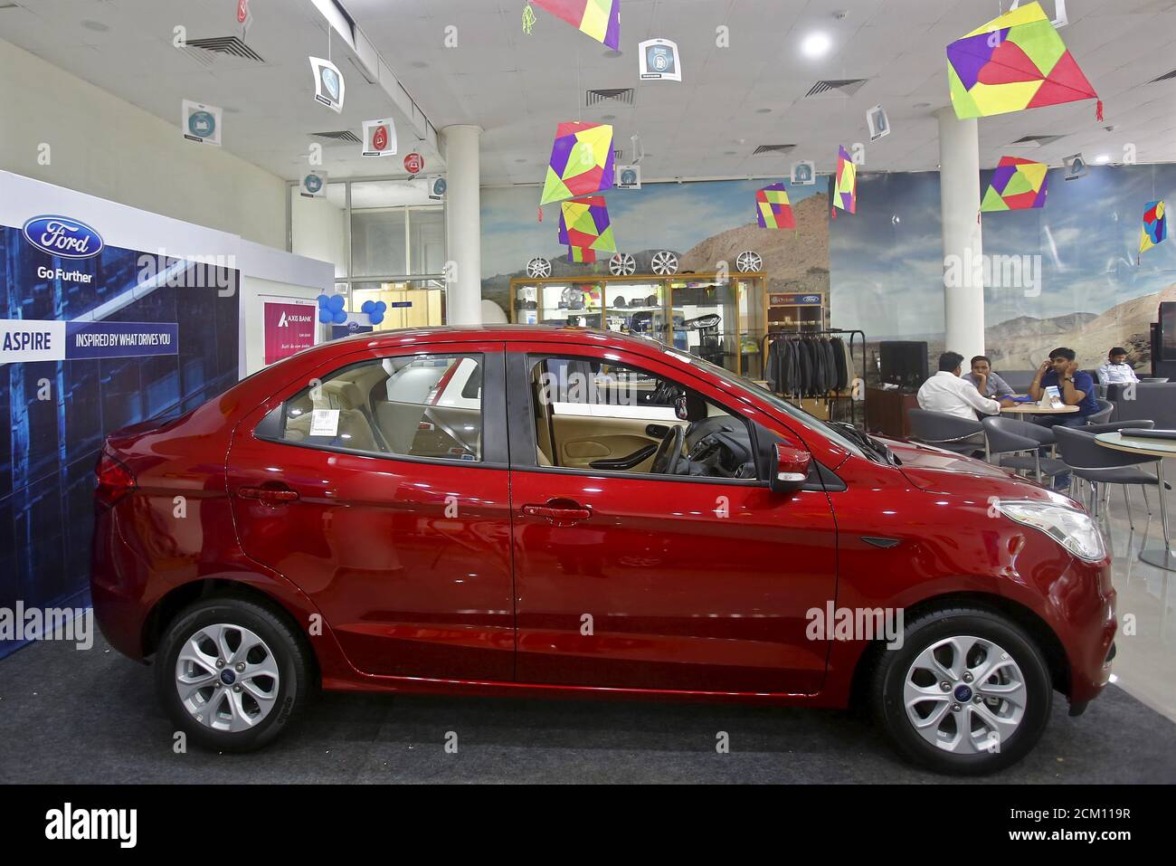 Les clients s'assoient près de la nouvelle voiture Figo Aspire de Ford  exposée dans une salle d'exposition à New Delhi, en Inde, le 11 août 2015.  Ford Motor Co prévoit d'utiliser les