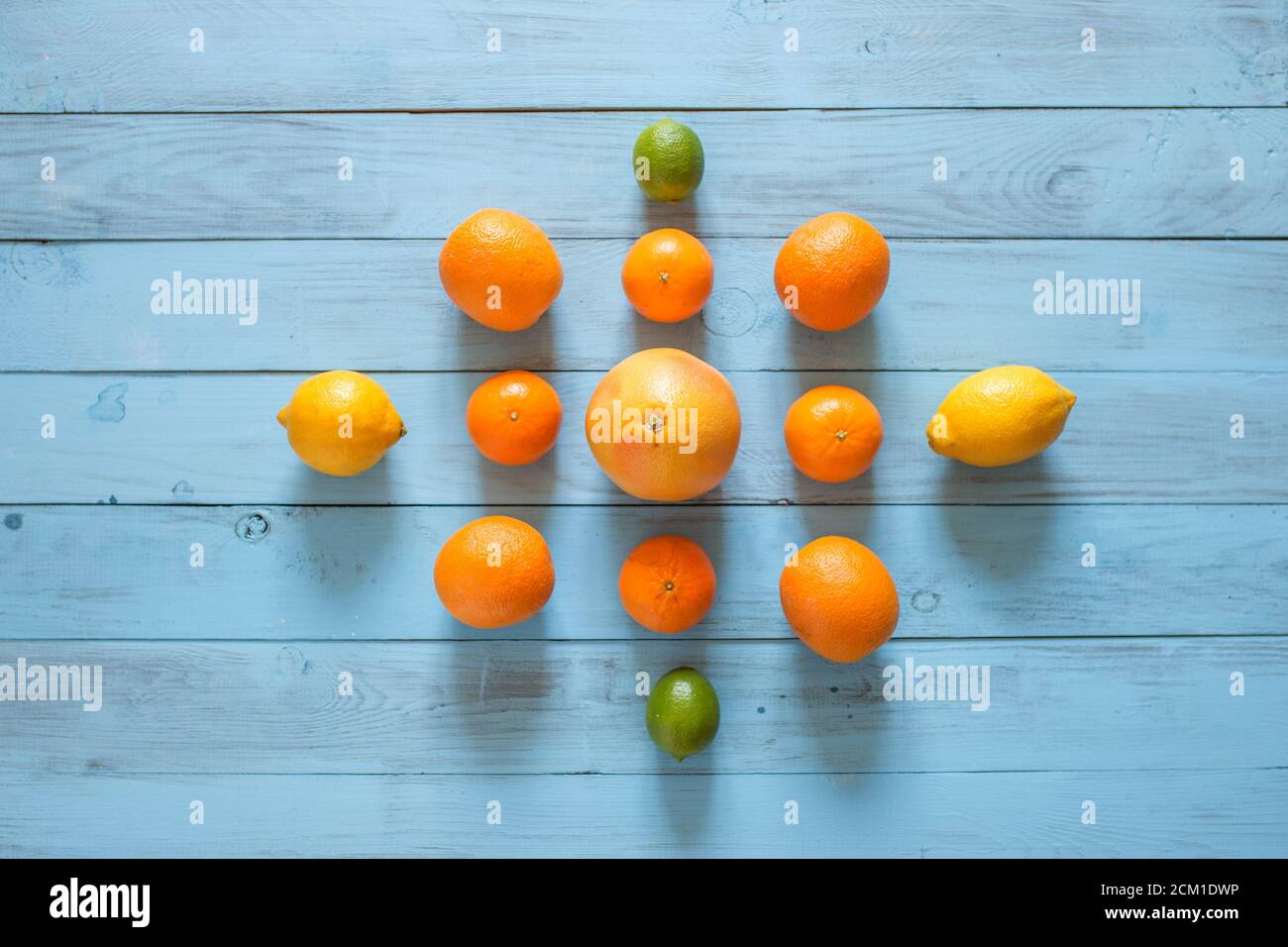 Agrumes entiers assorty de fruits colorés sur le milieu de fond texturé en bois bleu. Vue d'en haut. Copier l'espace. Banque D'Images