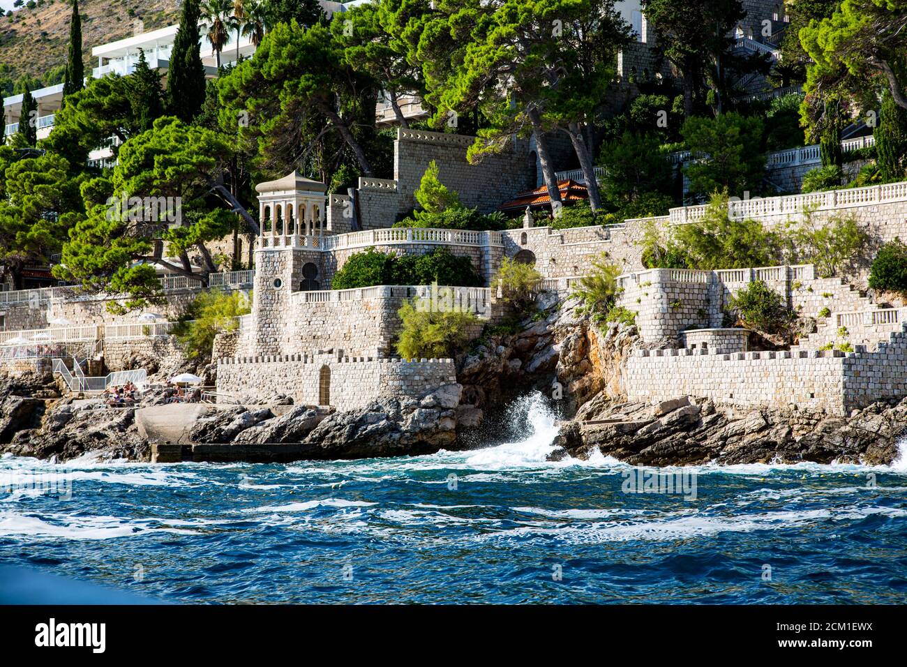 Hôtel en pierre au bord de la mer avec vague de rupture Banque D'Images