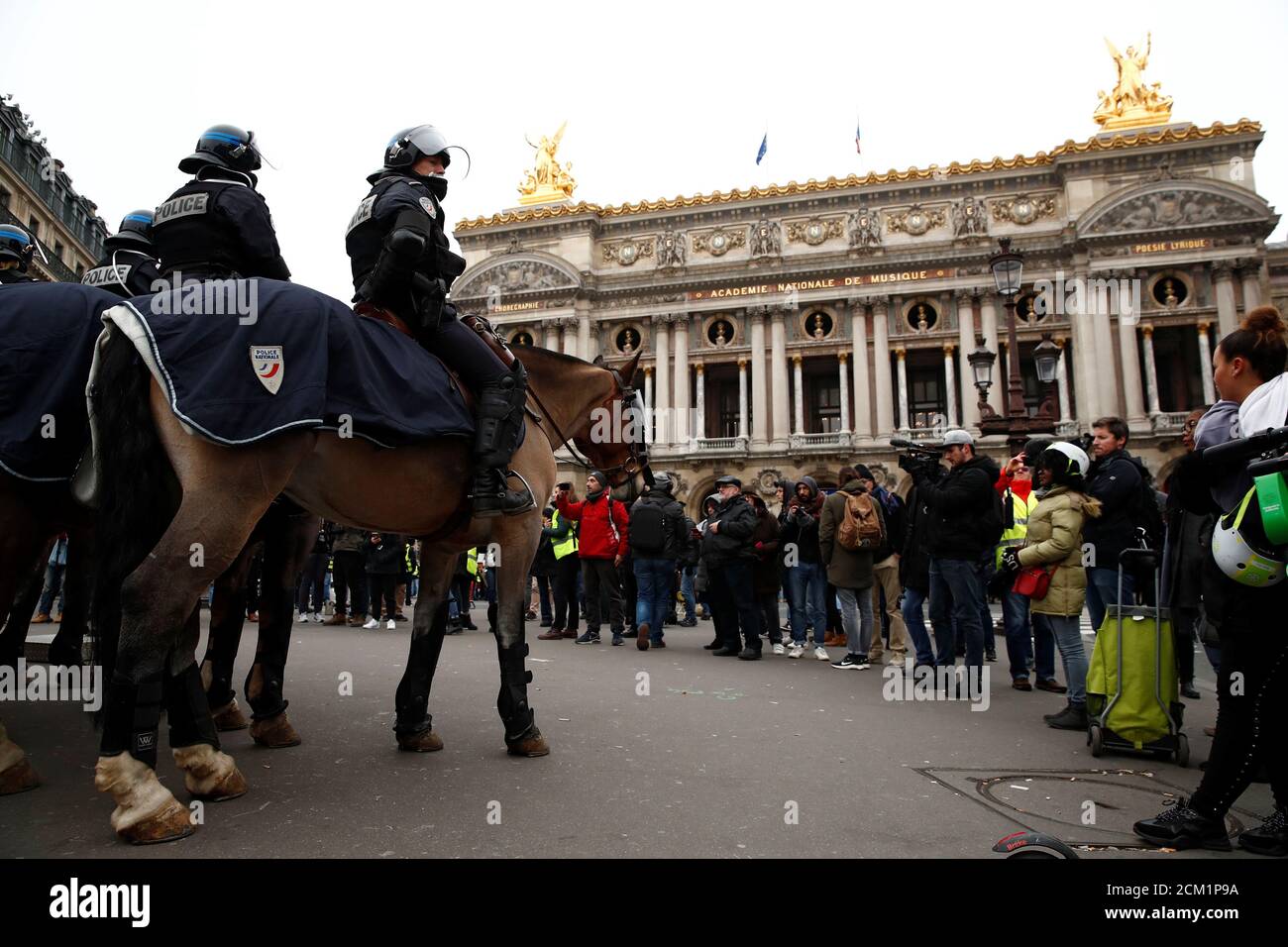 La police française montée forme une ligne à cheval devant l'Opéra, tandis  que les manifestants se rassemblent dans le cadre du mouvement des « gilets  jaunes » à Paris, France, le 15