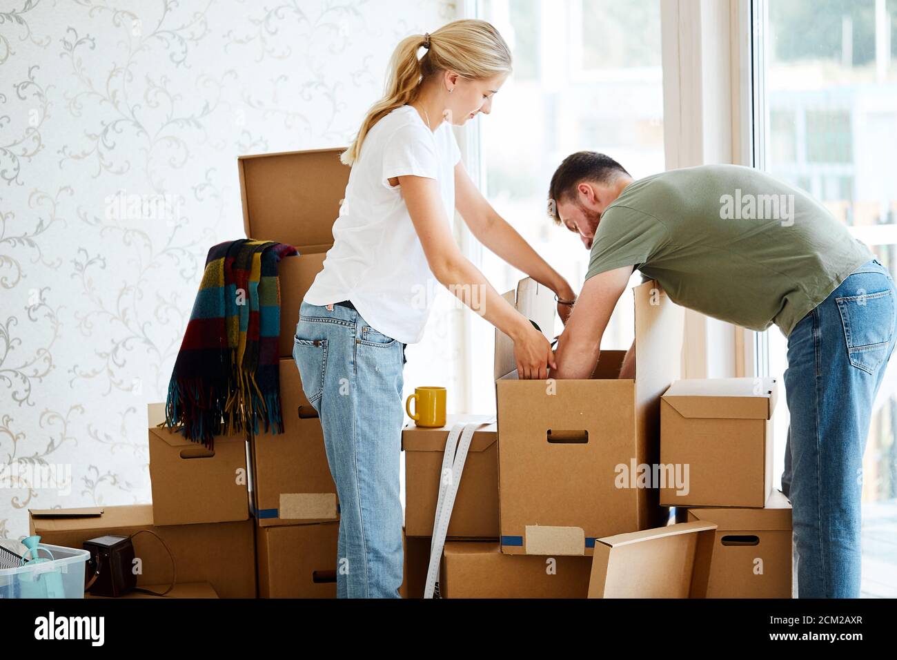 Jeune couple dans nouvel appartement déballage de boîtes de carton Banque D'Images