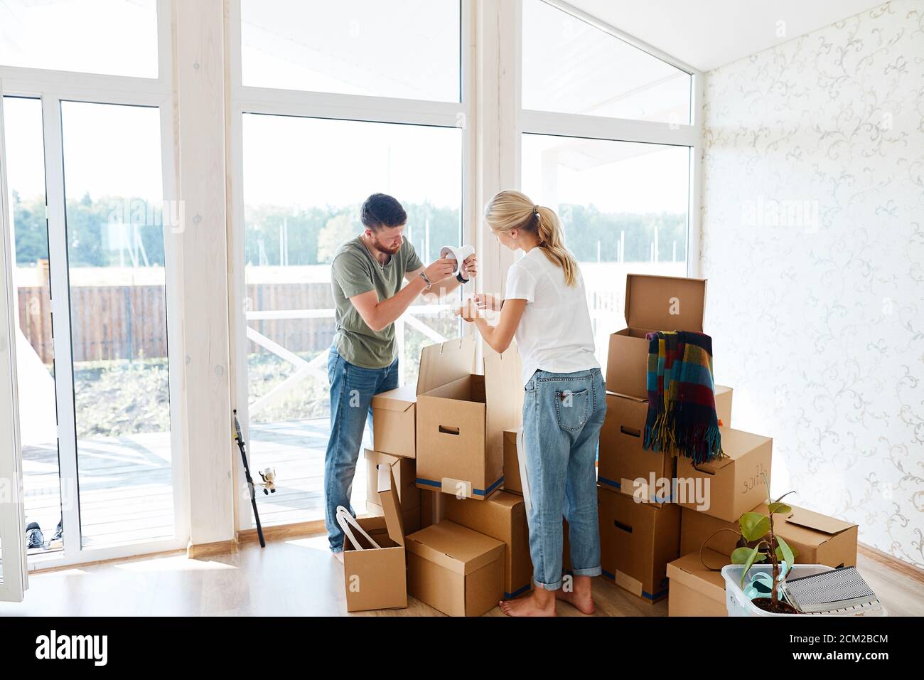 Jeune couple dans nouvel appartement déballage de boîtes de carton Banque D'Images