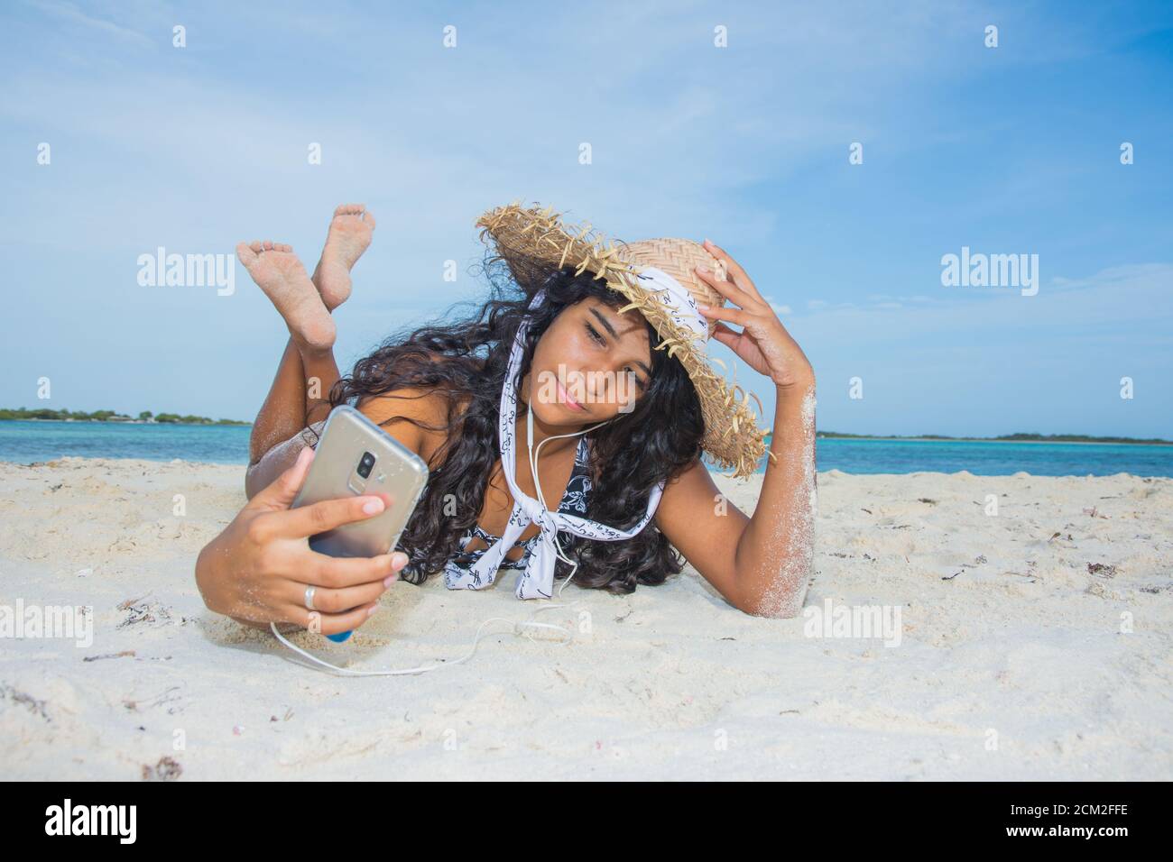 Jeune femme noire prenant un selfie à la plage Banque D'Images