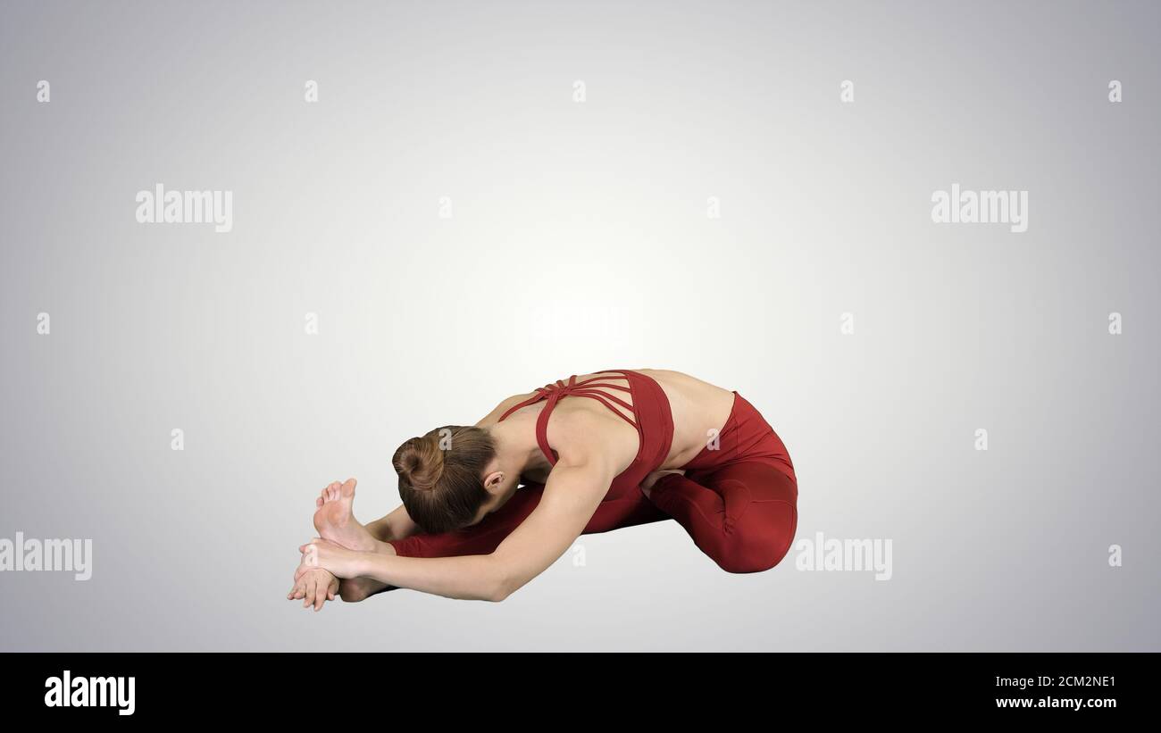 Jeune femme attirante pratiquant le yoga, assise de la tête au genou Banque D'Images