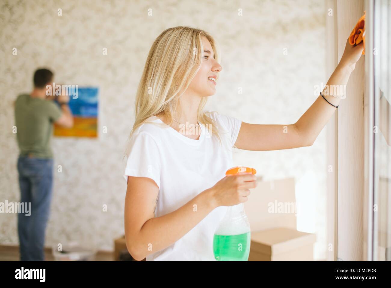 Belle femme ou femme de ménage utilisant un chiffon en microfibre pour  nettoyer la fenêtre de la nouvelle maison après déménagement Photo Stock -  Alamy