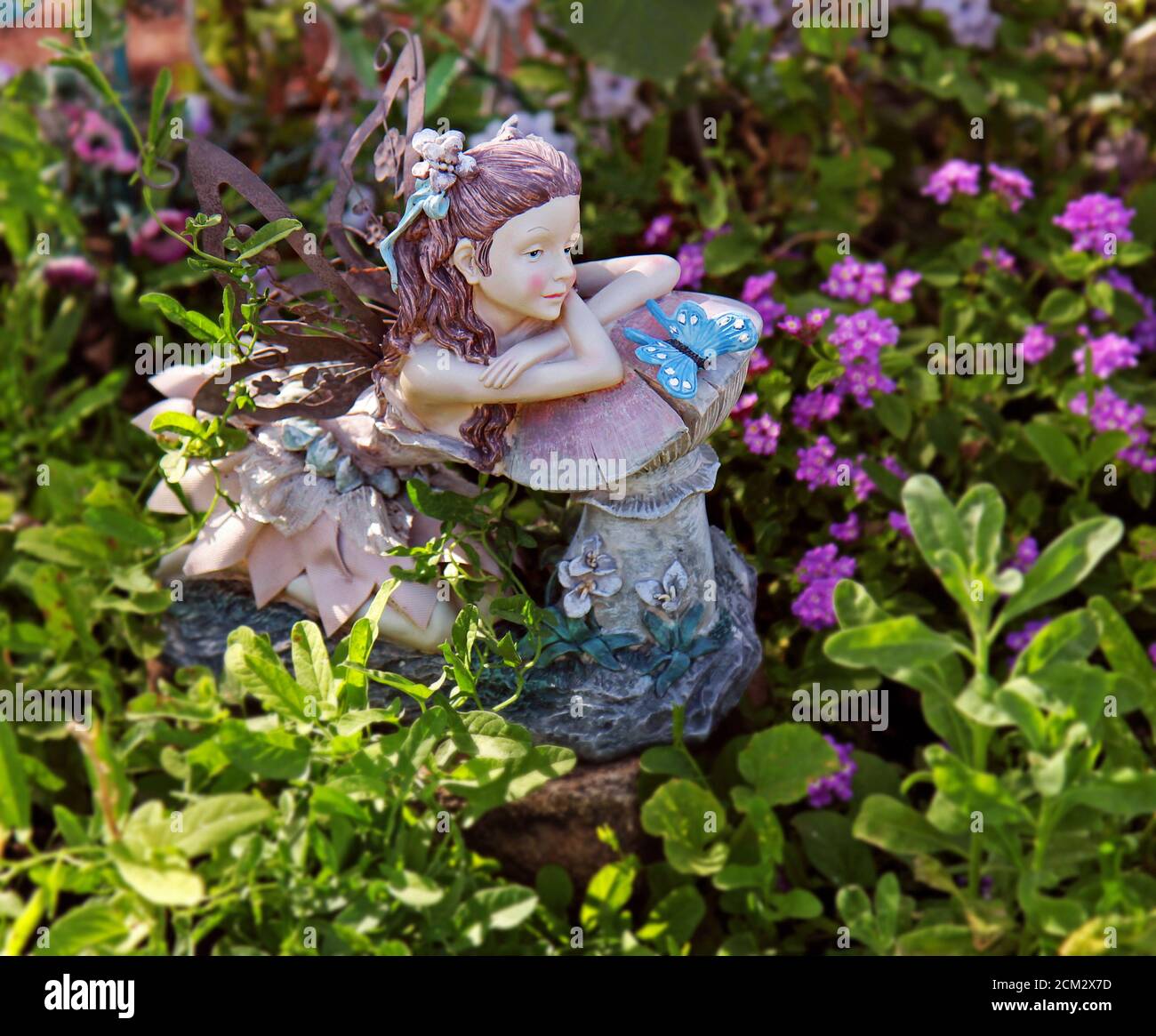 Une figurine de fées orne un petit jardin. Banque D'Images