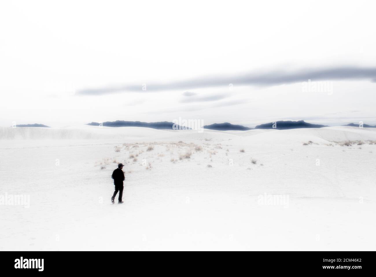 Vue sur les dunes de sable de gypse du parc national de White Sands avec une personne qui marche entre les dunes. Banque D'Images