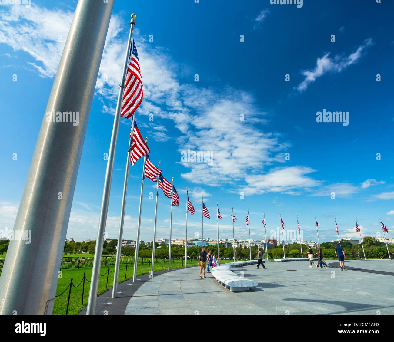 Les drapeaux des États-Unis sur les poteaux placés autour de la base du Washington Monument à Washington, DC lors d'une journée ensoleillée d'été Banque D'Images