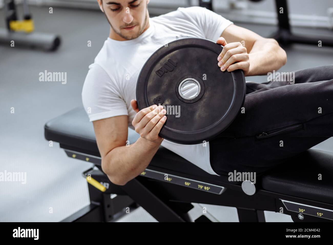 Caucasien forte instructeur de forme physique faisant l'entraînement abs et de construction athlétique corps au gymnase bien équipé Banque D'Images