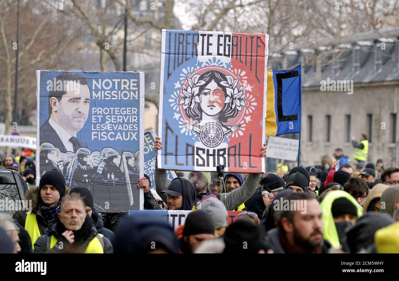 Les manifestants portant des gilets jaunes participent à une manifestation  organisée par le mouvement des gilets jaunes, à Paris, en France, le 19  janvier 2019. Les panneaux indiquent « notre mission. Protéger