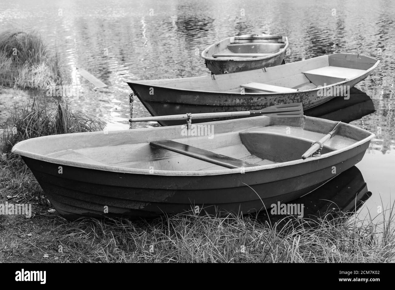 Les barques sont sur la côte d'un lac encore, photo en noir et blanc Banque D'Images