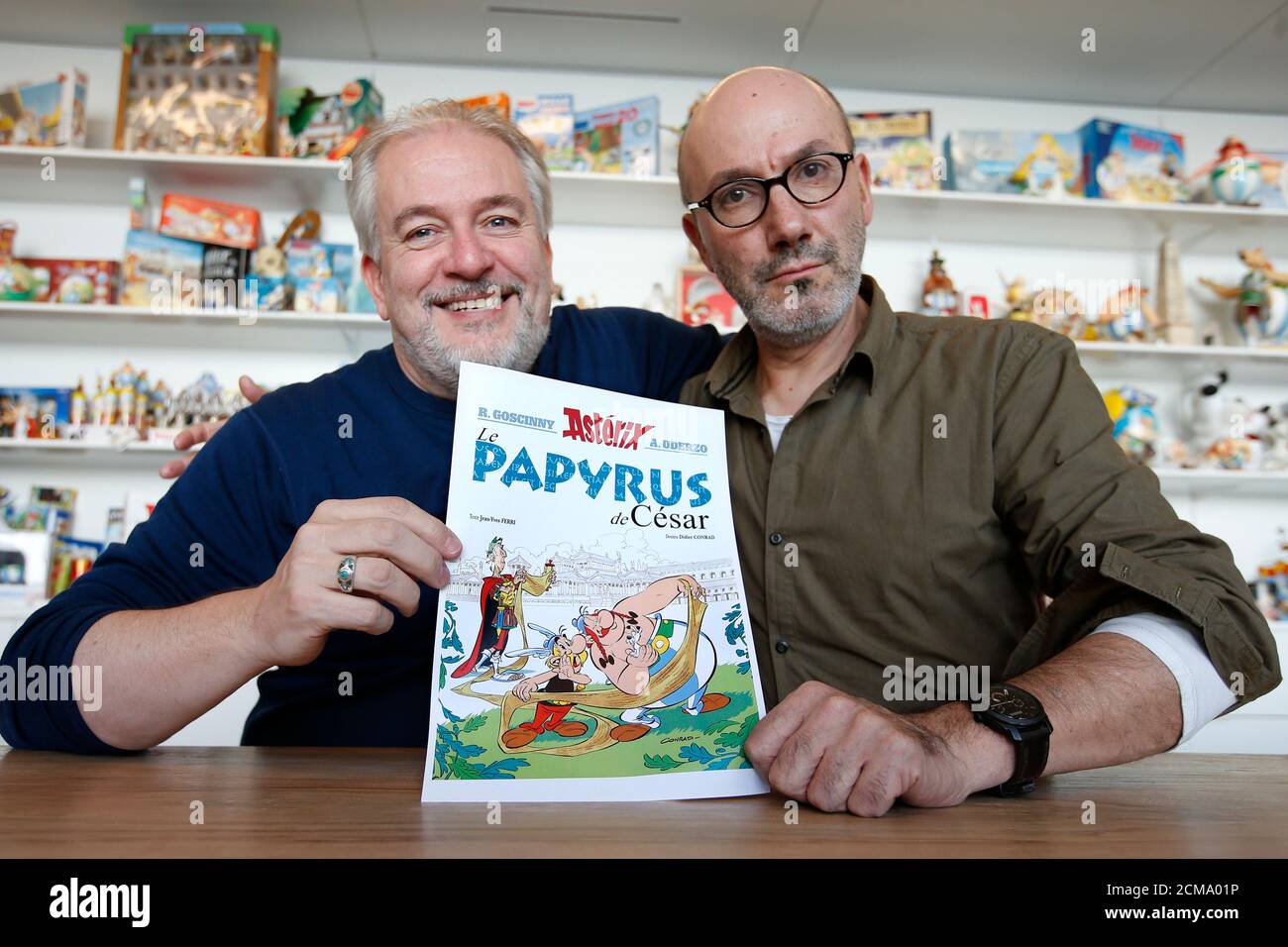 L'auteur Jean-Yves Ferri (R) et l'illustrateur Didier Conrad (L) posent  avec une impression de la couverture de leur nouveau livre comique 'le  Papyrus de Cesar' (Astérix et le Déparchemin manquant) à Vanves,