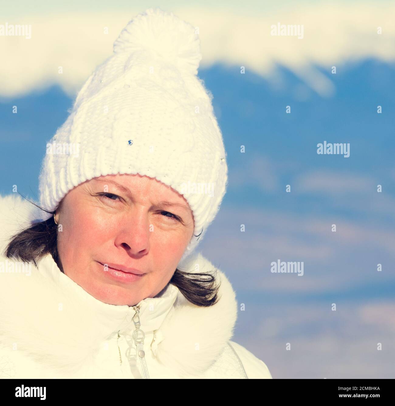 La femme du nombre moyen d'années dans un chapeau tricoté blanc Banque D'Images