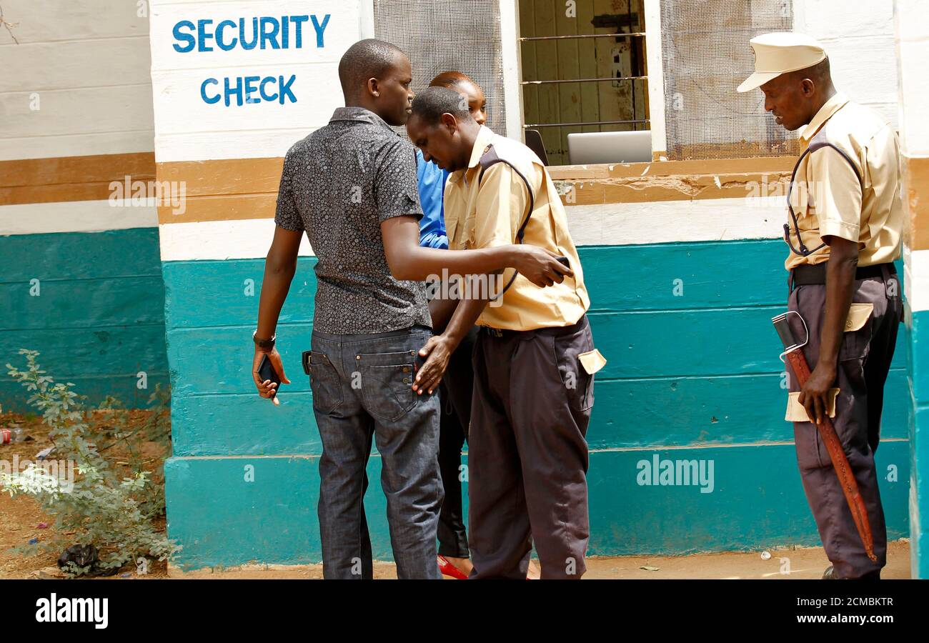Un agent de sécurité recherche un étudiant à l'entrée du Collège universitaire de Garissa alors que les étudiants retournent sur le campus de la ville de Garissa, au nord-est du Kenya, le 11 janvier 2016. Le campus a rouvert aujourd'hui neuf mois après une attaque par des militants islamistes basés en Somalie, Al-Qaïda, liés à Al-Shabaab. REUTERS/Thomas Mukoya Banque D'Images