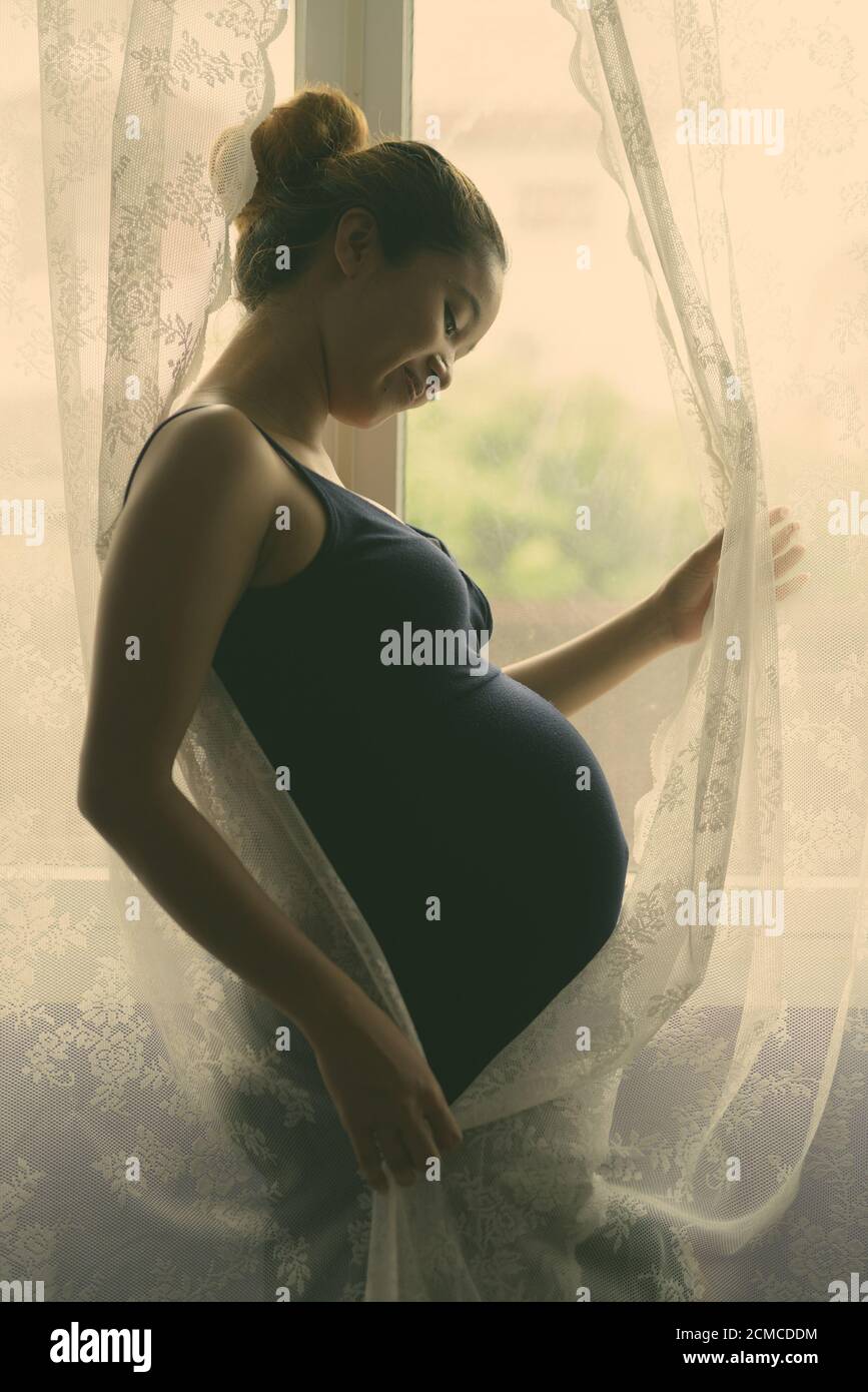 Mère aimer son bébé en silhouette par la fenêtre Banque D'Images