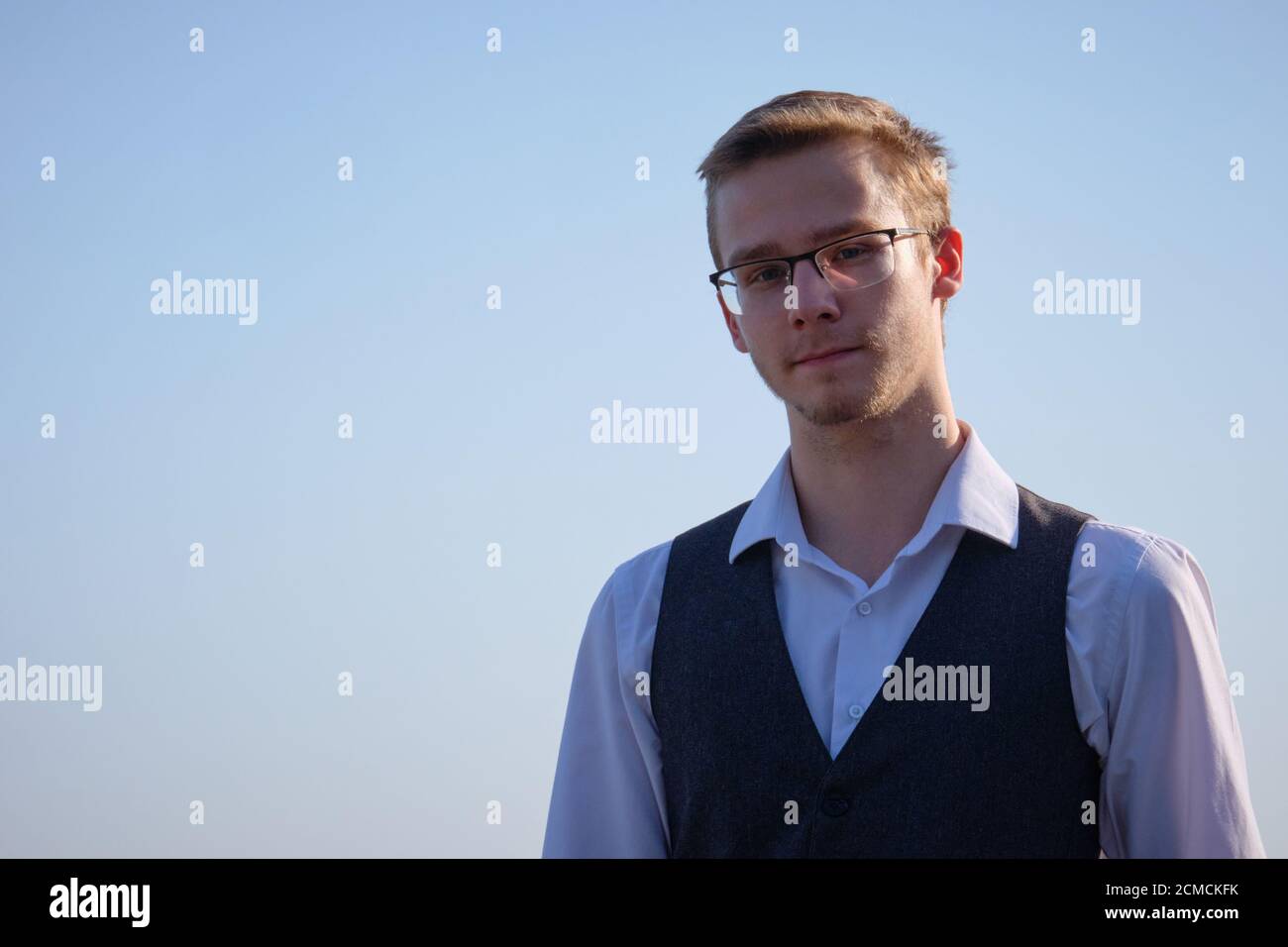 Jeune homme à lunettes vêtu d'une chemise blanche et d'un gilet Banque D'Images