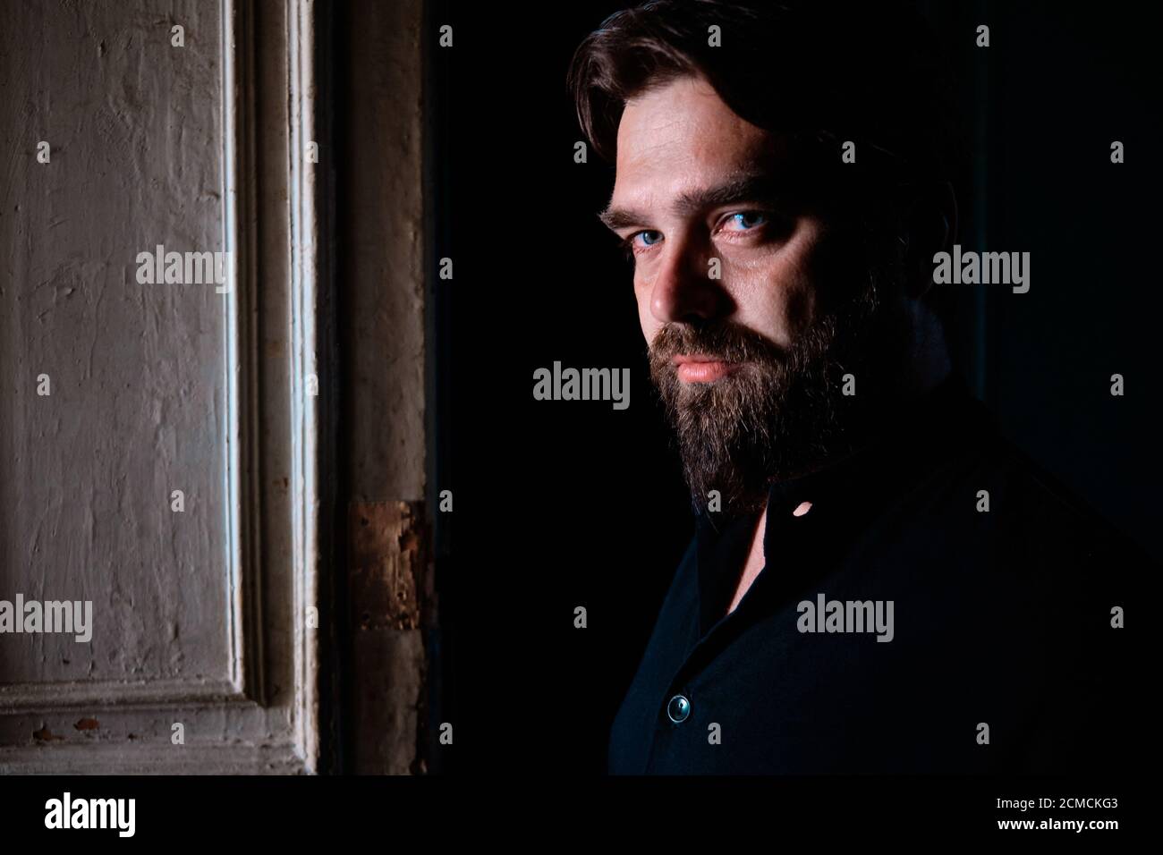 Portrait de l'homme charismatique aux yeux bleus barbu avec un regard Banque D'Images